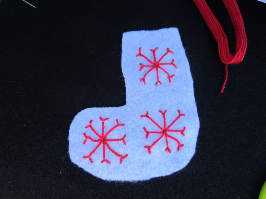 Three snowflakes are stitched on the ornament
