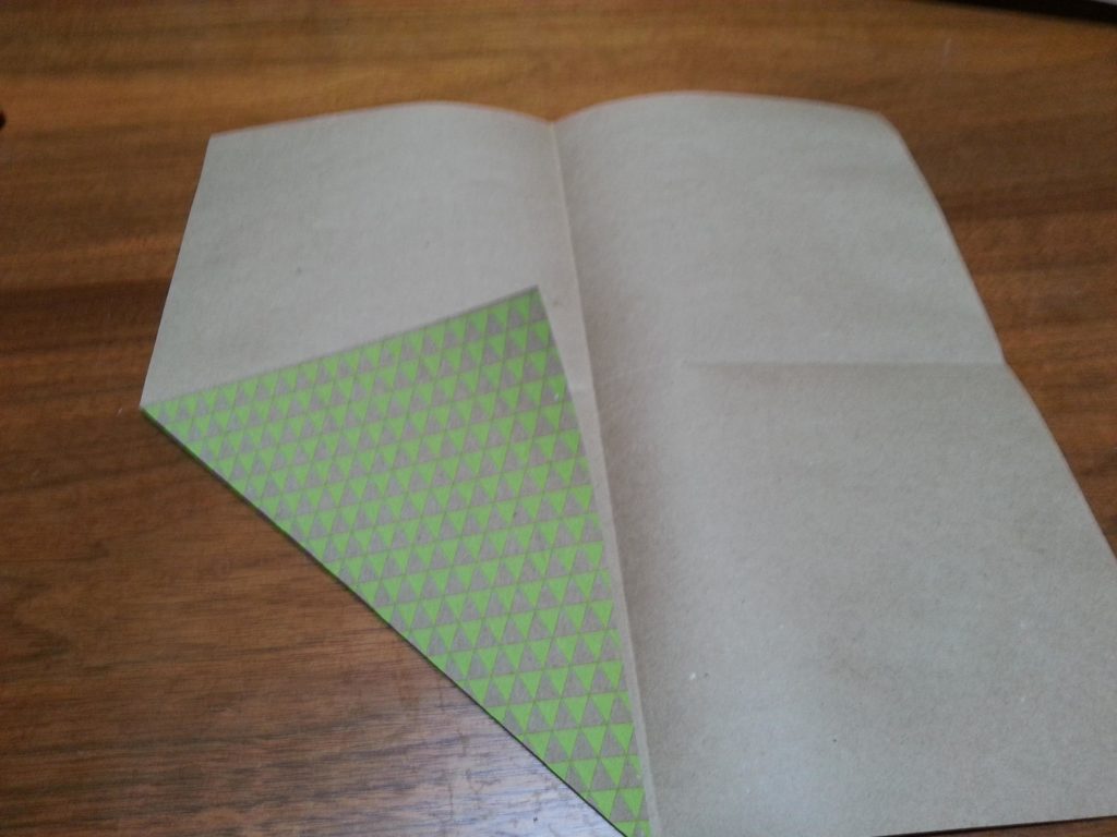 Fold the paper in half the other direction to form 4 squares. Turn in each corner to make triangles