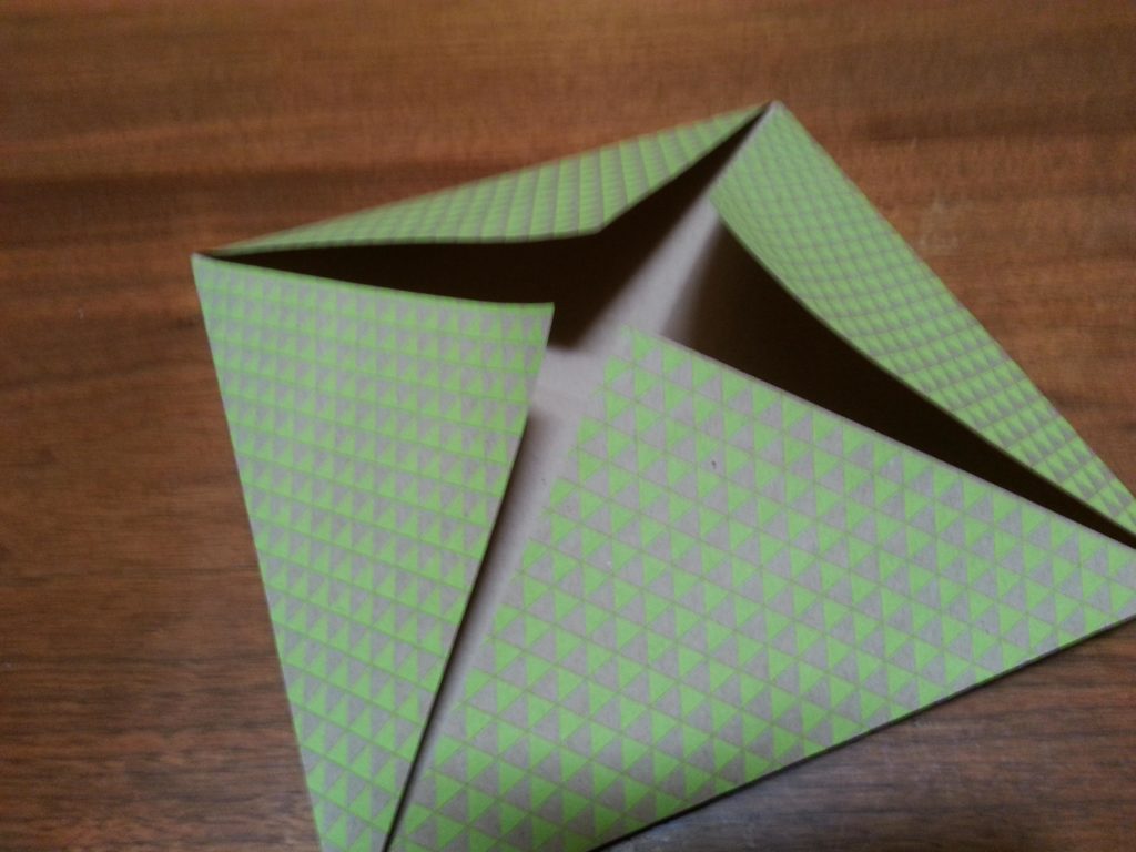 Fold in all four corners to center to form a square