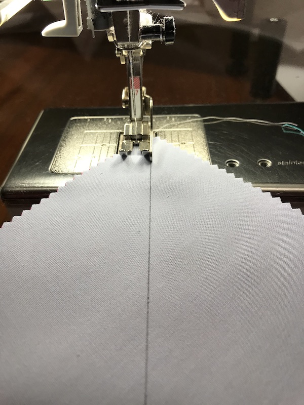 Sewing the first seam to make eight half square triangles at a time from a layer cake