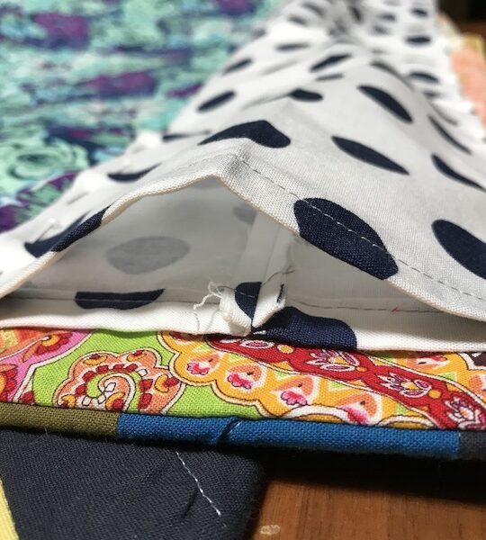 Pinned quilt sleeve to quilt back