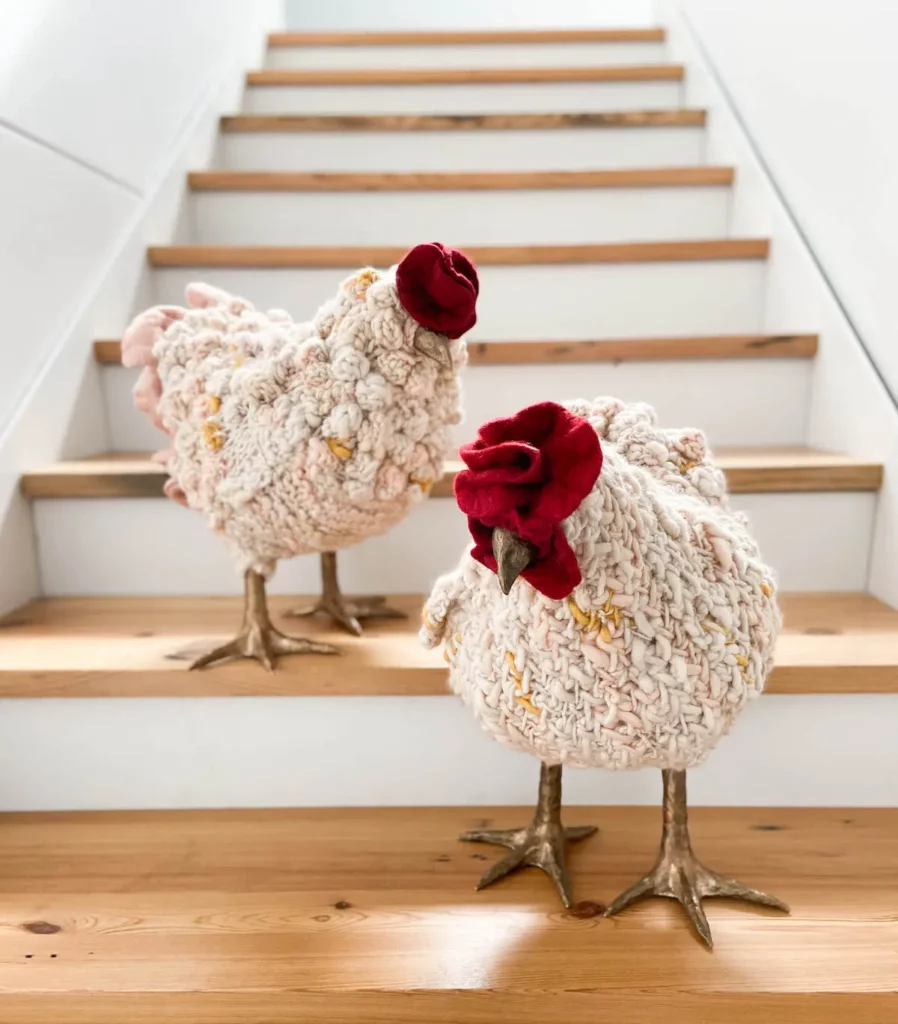 Two white fiber art chickens on the stairs