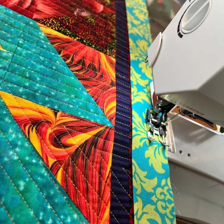 Beginning to sew the binding to the quilt top