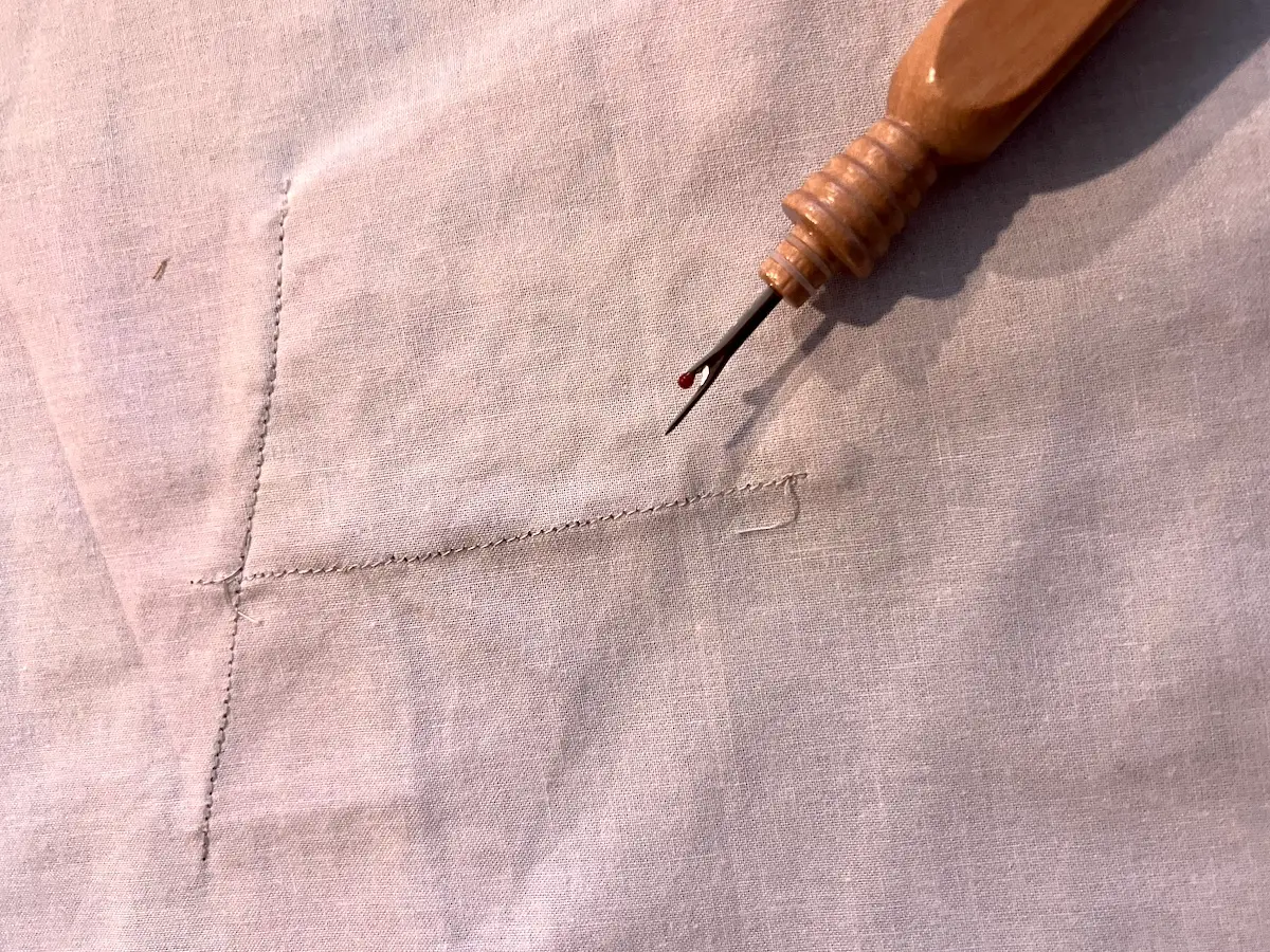Unstitching a few stitches to trim back a previously sewn fabric