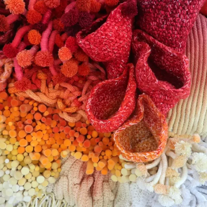 Close up of a yellow orange and red fiber art piece by Erik Speer