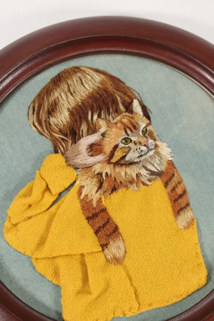 Lady holding a cat embroidery stitched by Amanda Fox