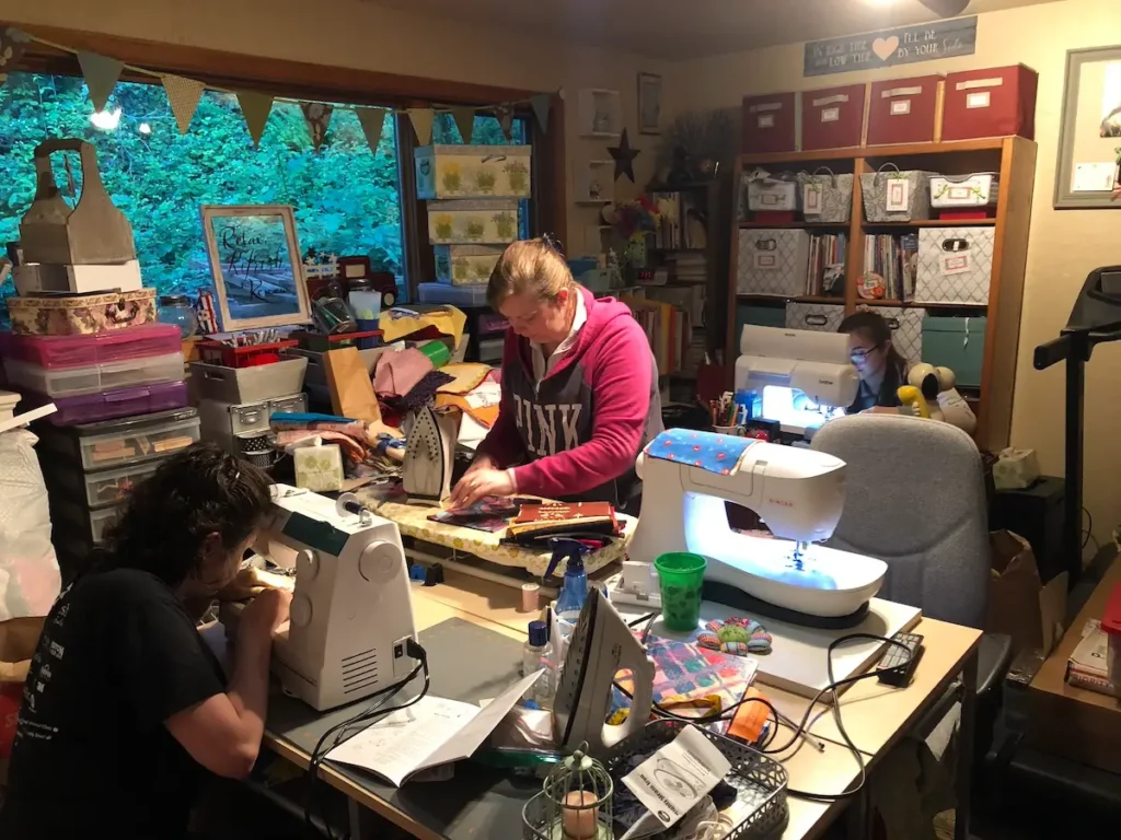 Monique Arnold and two young ladies sewing