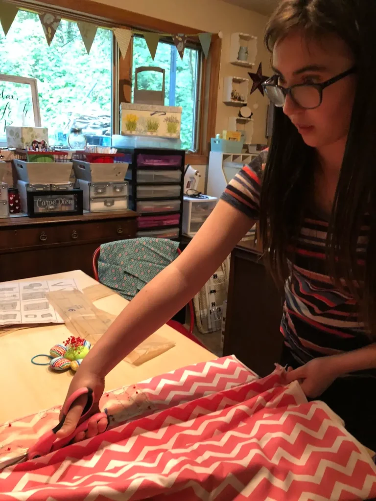 Teenager cutting fabric in Monique Arnold studio