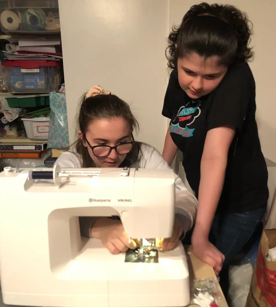 Two young girls at a sewing machine in Monique Arnold interview