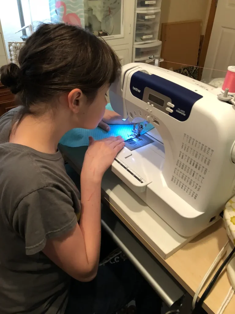 Young girl at a sewing machine with Monique Arnold