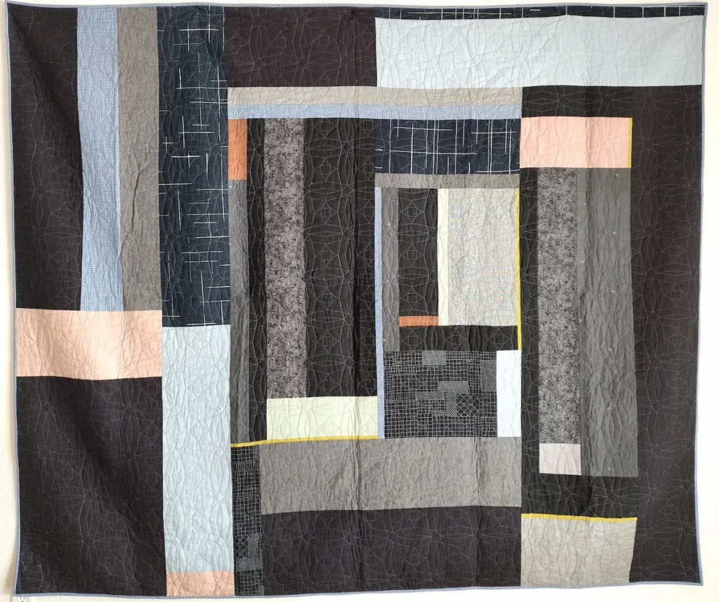 Blue, black and peach quilt by Ashelyn Downs
