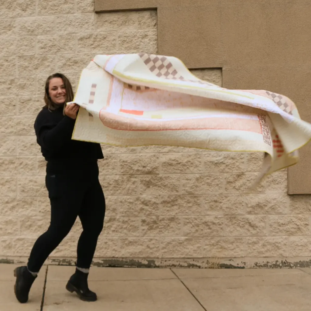 Ashelyn Downs with a pink and taupe quilt in the wind