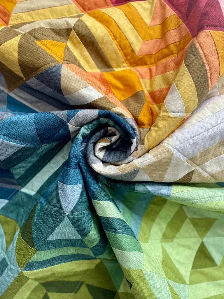 Curled up colorful quilt by Jen Wagner