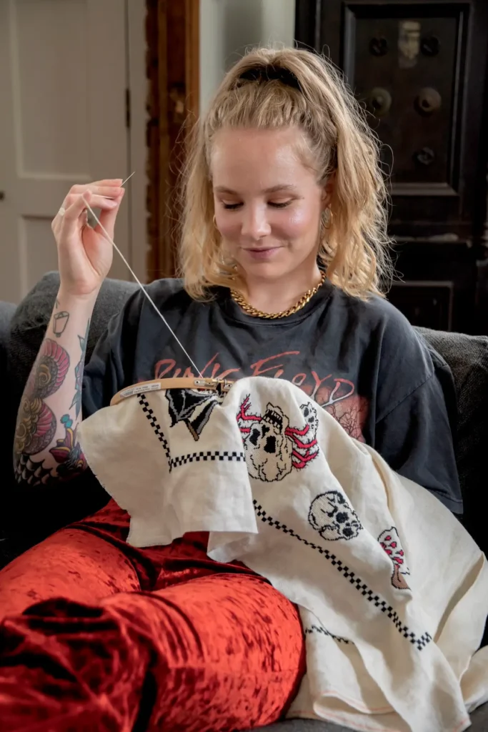 Maddie Jones working on a skull cross stitch