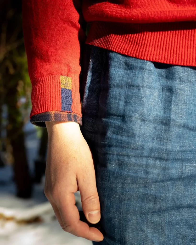 Mended cuff on an orange sweater by Minttu Wikberg