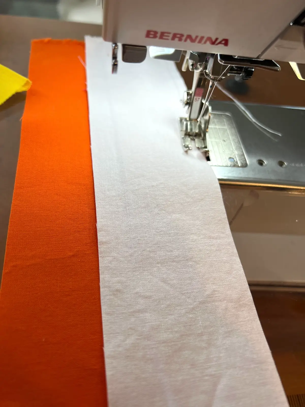 Sew the white strip of fabric to the orange strip for the candy corn bowl fillers