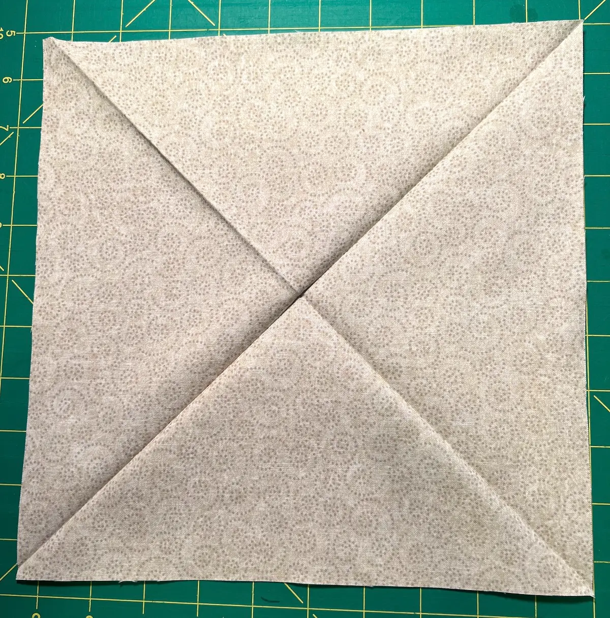 For placement of the elements for the Christmas Cactus quilt block, press the square to form diagonal lines in both directions.