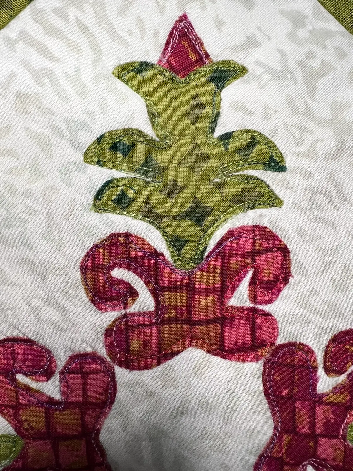 Showing the stitching around the applique pieces on the christmas cactus qult block