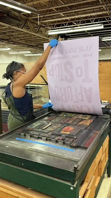 Jenn Graves pulling a print off the press