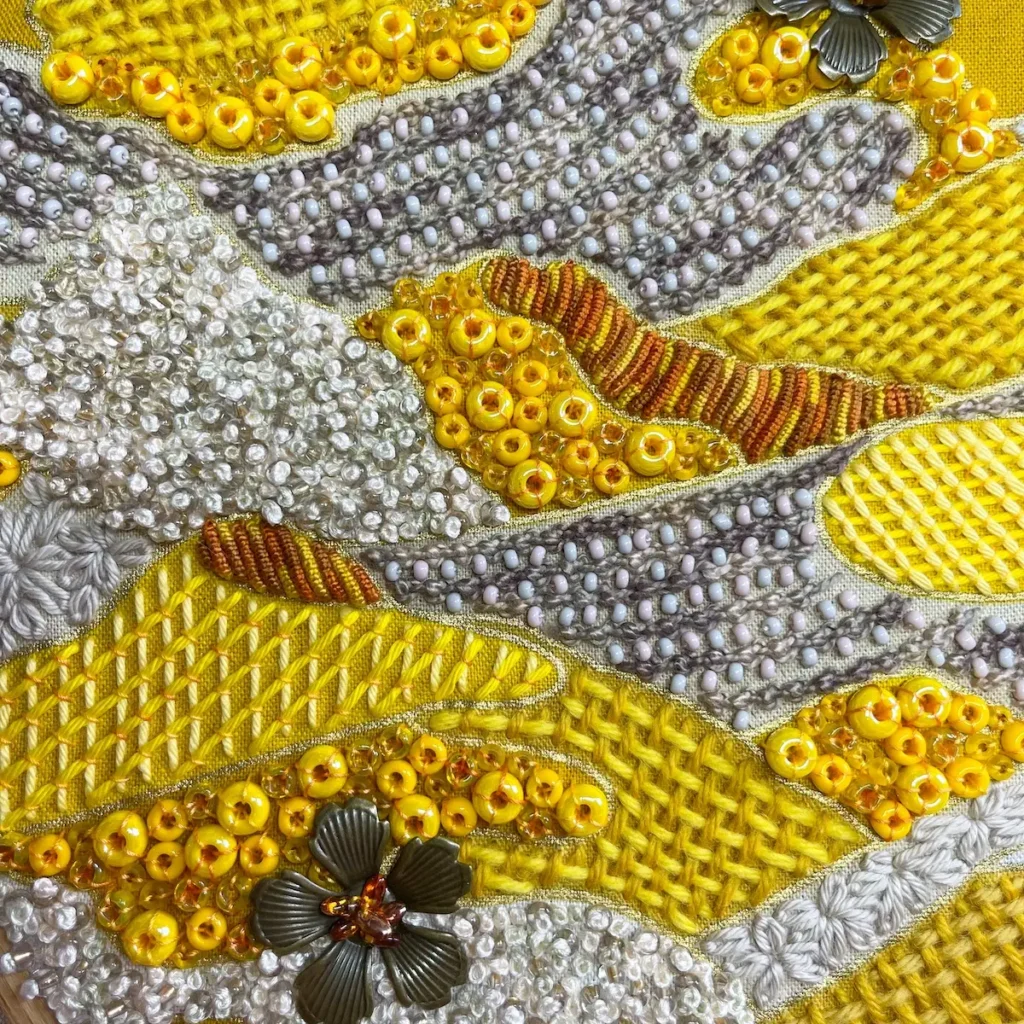 Detail of the hand stitching an beading on a piece by Nichole Vogelsinger