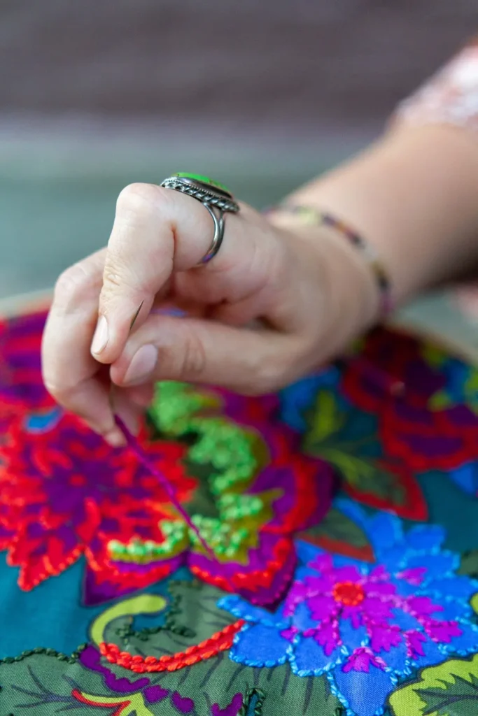 Nichole Vogelsinger hand stitching a piece