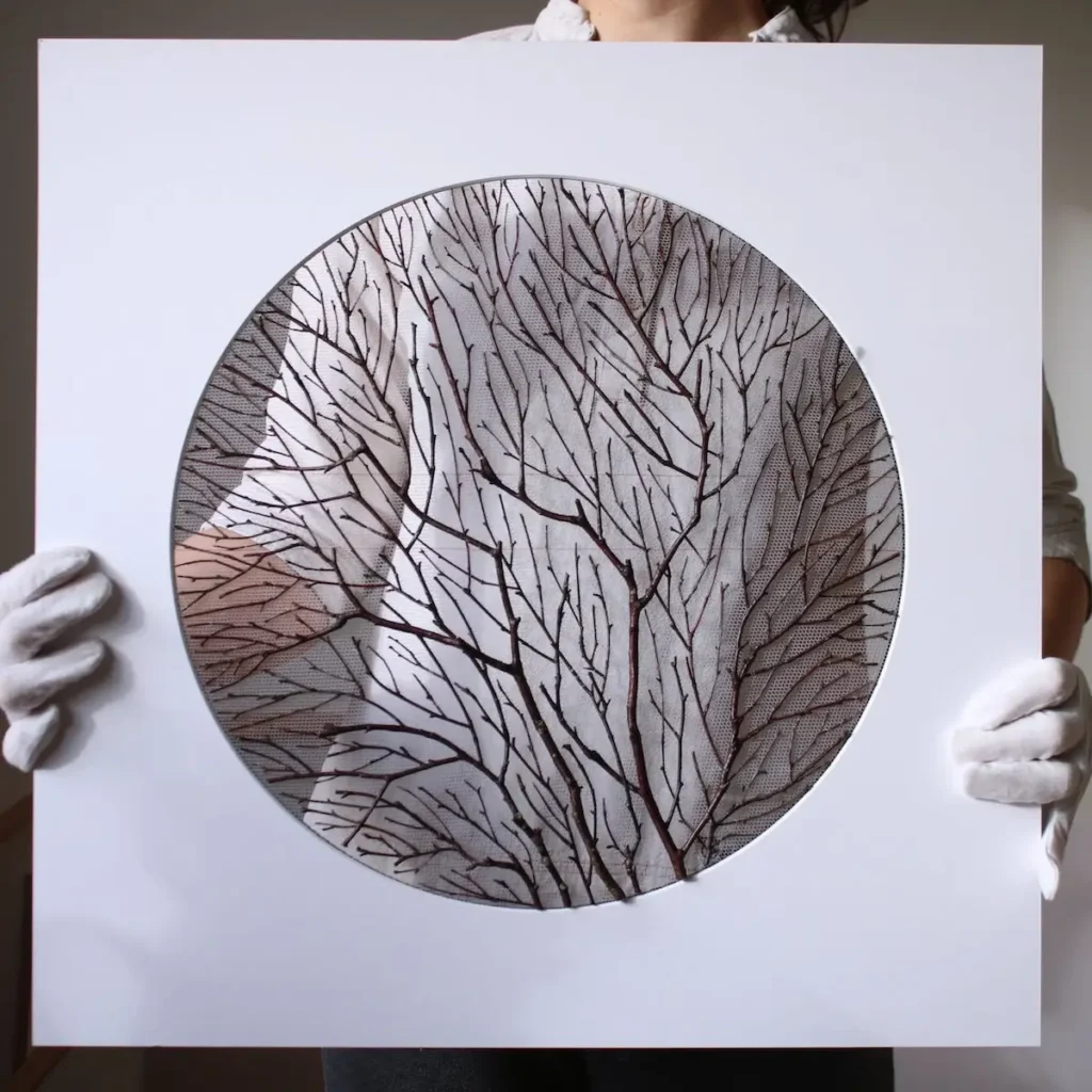 Olga Prinku holding up a piece with twigs in a circle template