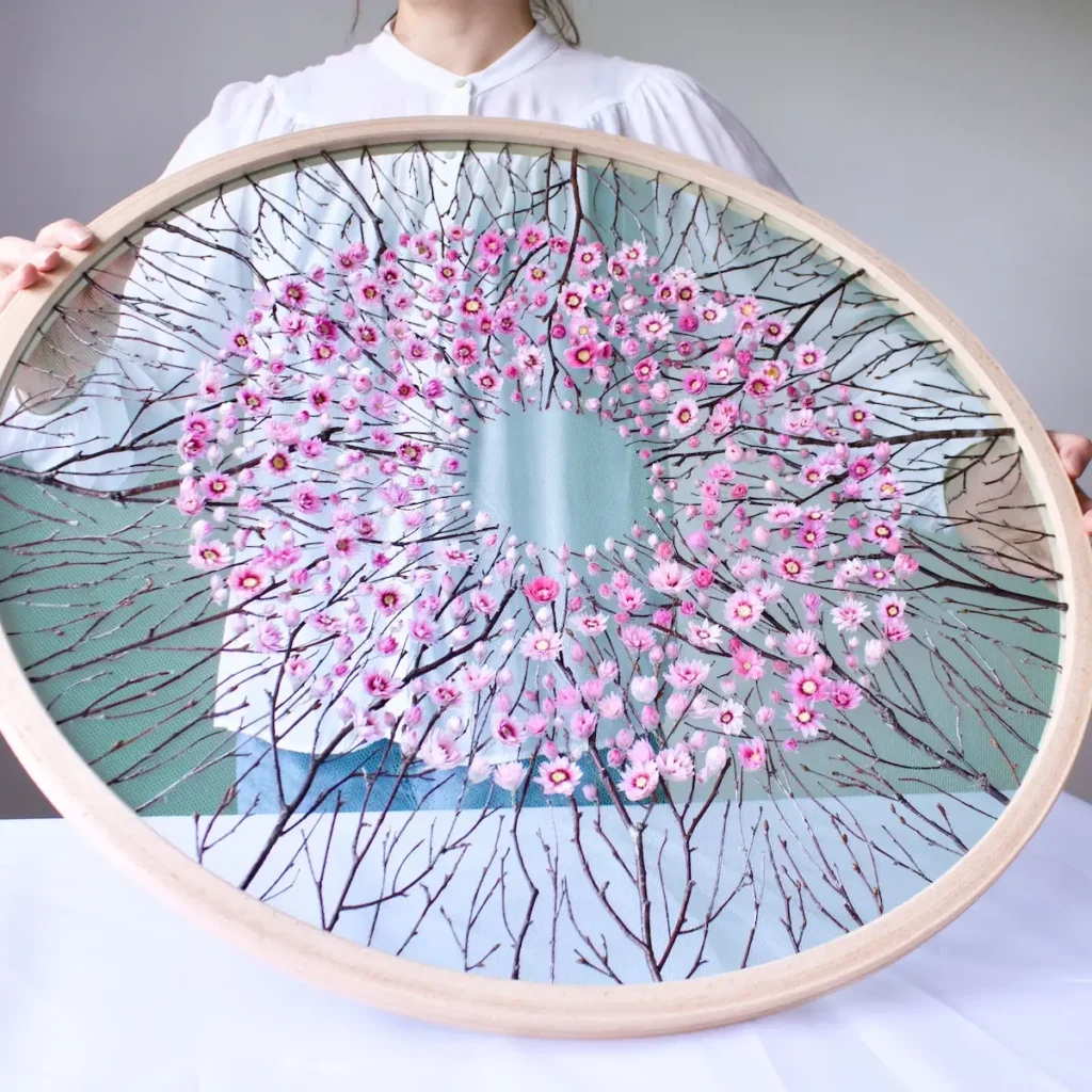 Under the Blossom Canopy Olga Prinku holding up the frame