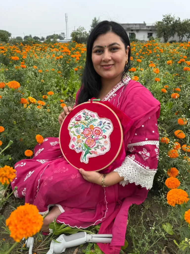 Radhika Vyas with flower embroidery in the middle of a field of marigolds