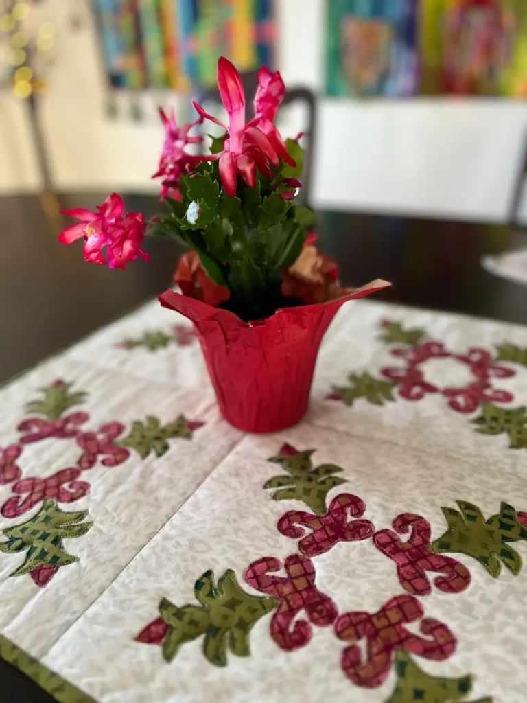 Christmas Cactus quilt block finished on table with a plant