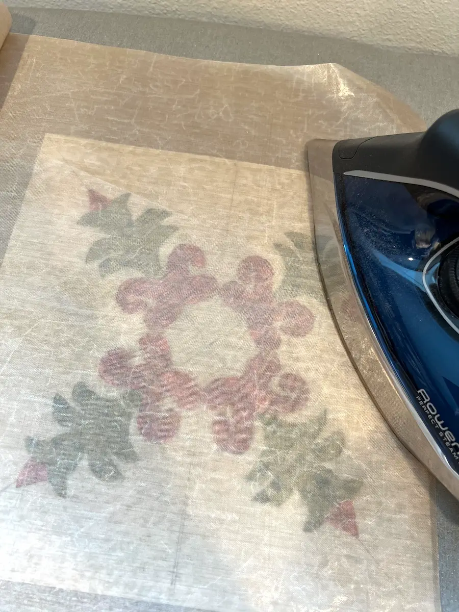 Christmas Cactus quilt block pressing the applique pieces to the background on a block