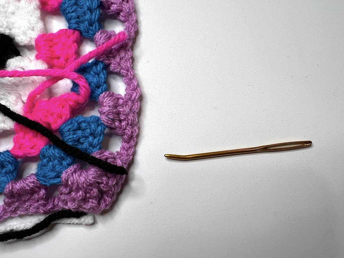 Showing the needle next to the granny square