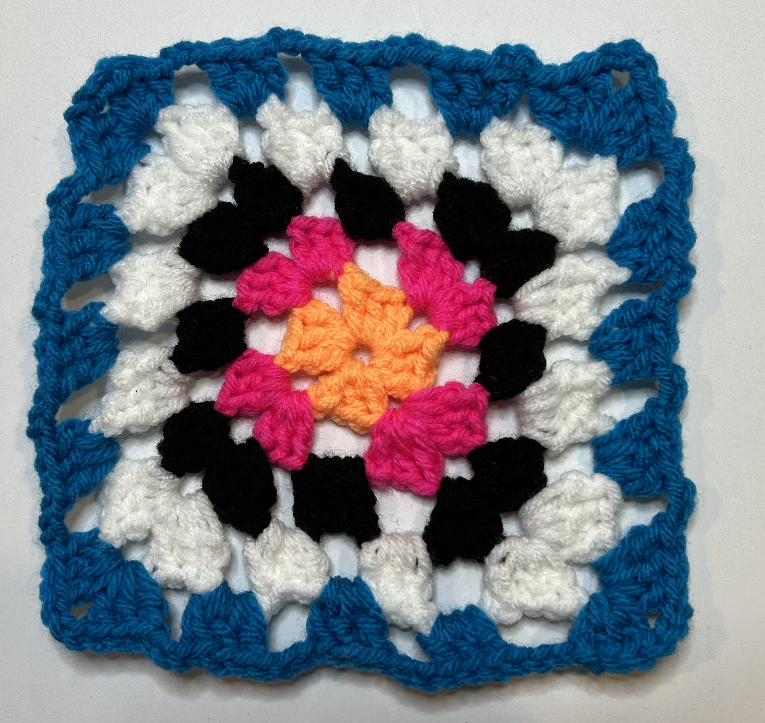 Blue, white, black, pink and orange granny square finished