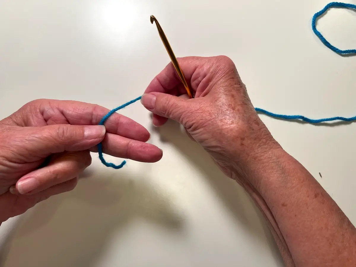 Begin a granny square with laying the tail of the thread over two fingers - the start of the magic circle