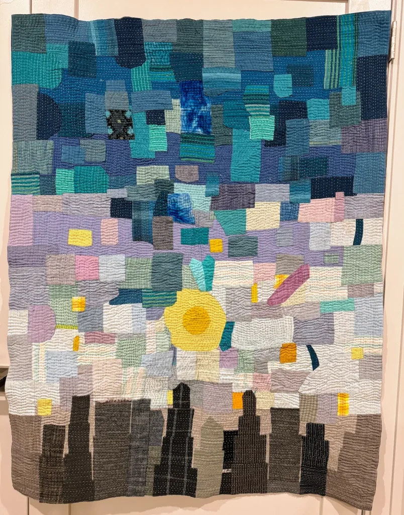 Blue, lavender and grey scrappy quilt by Jennifer Strauser