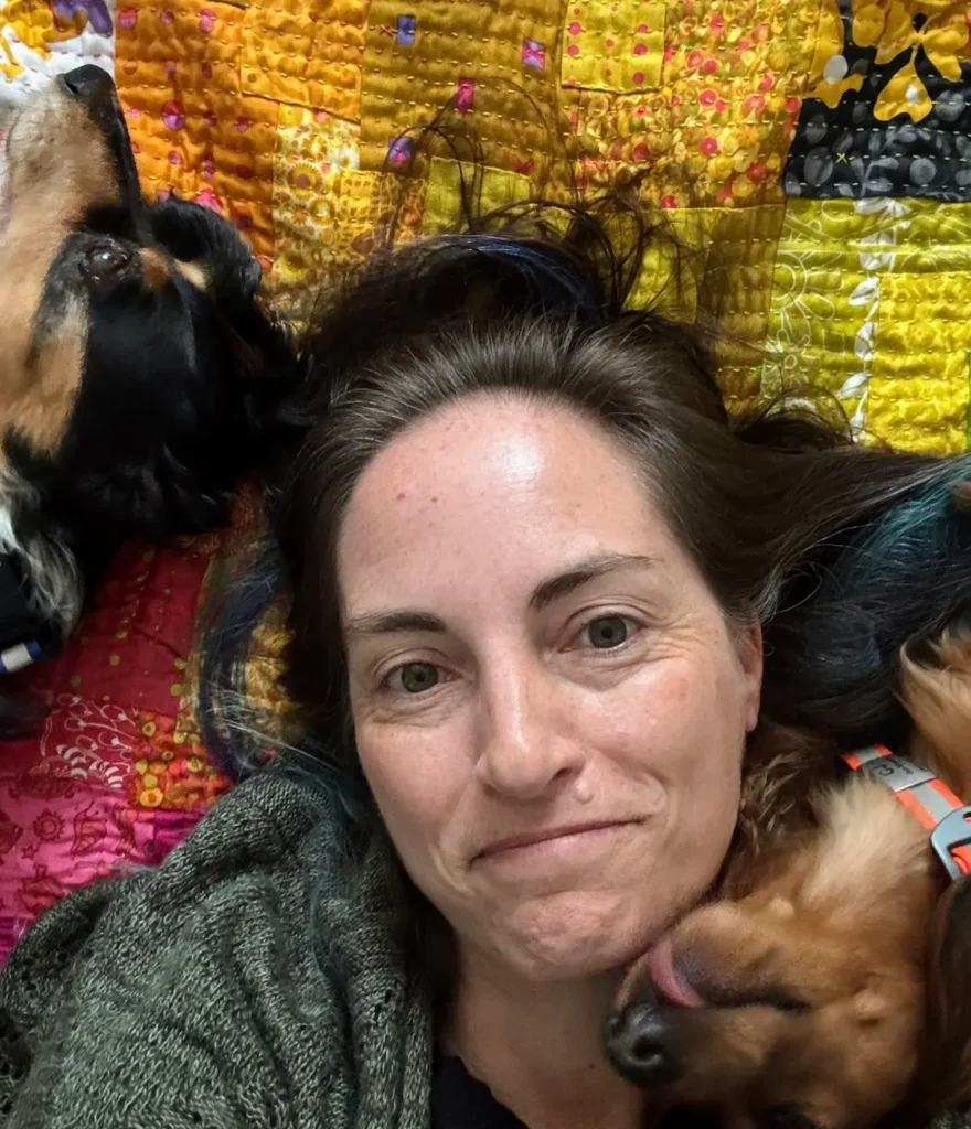 Jennifer Strauser and her dogs on a quilt