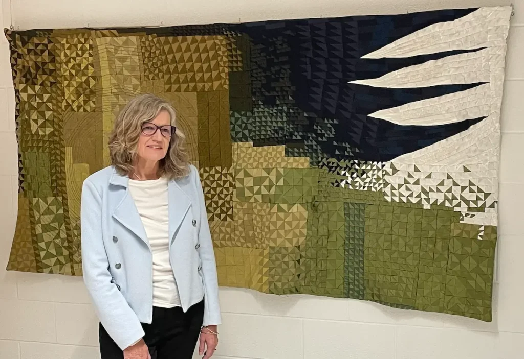 Victoria Carley with her quilt The Seventh Jacket at World of Threads
