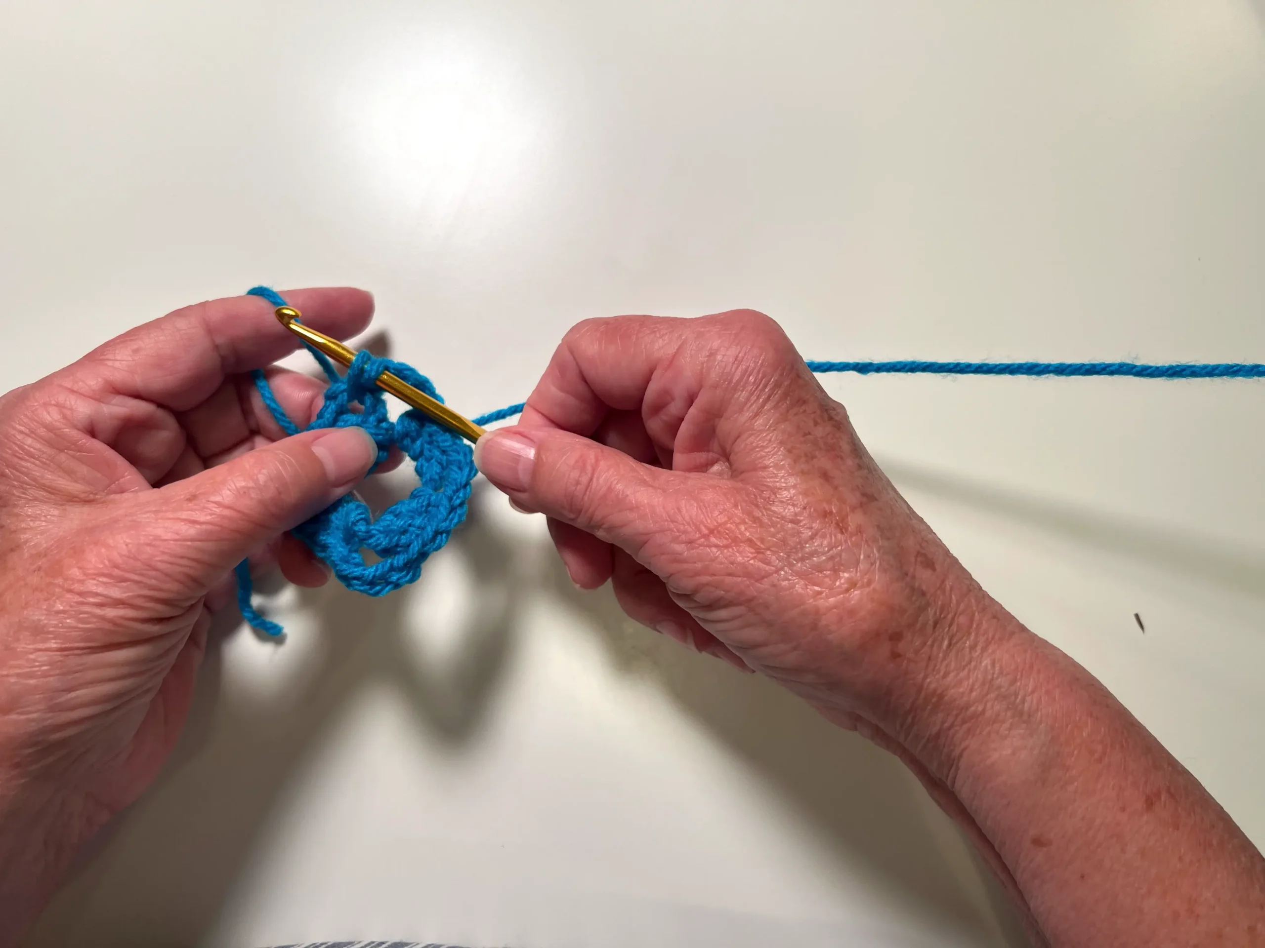 To finish the round, slip the hook in between the chain and double crochet stitches where you began