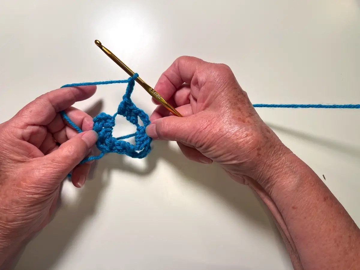 Keep going with three double crochet, three chain stitches until there are four set of each completed for the granny square