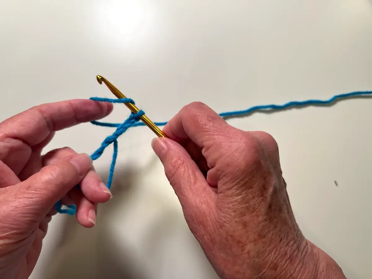 Wrap the yarn around the hook to begin the first double crochet for the granny square