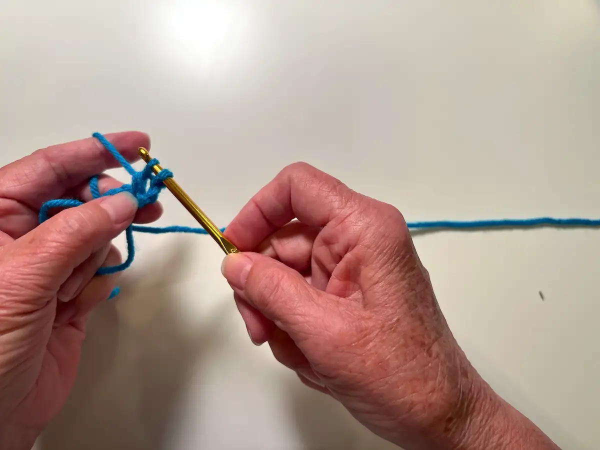 Now there are two stitches left on the hook. Wrap the yarn around the hook and bring through those stitches to make the double crochet stitch for the granny square