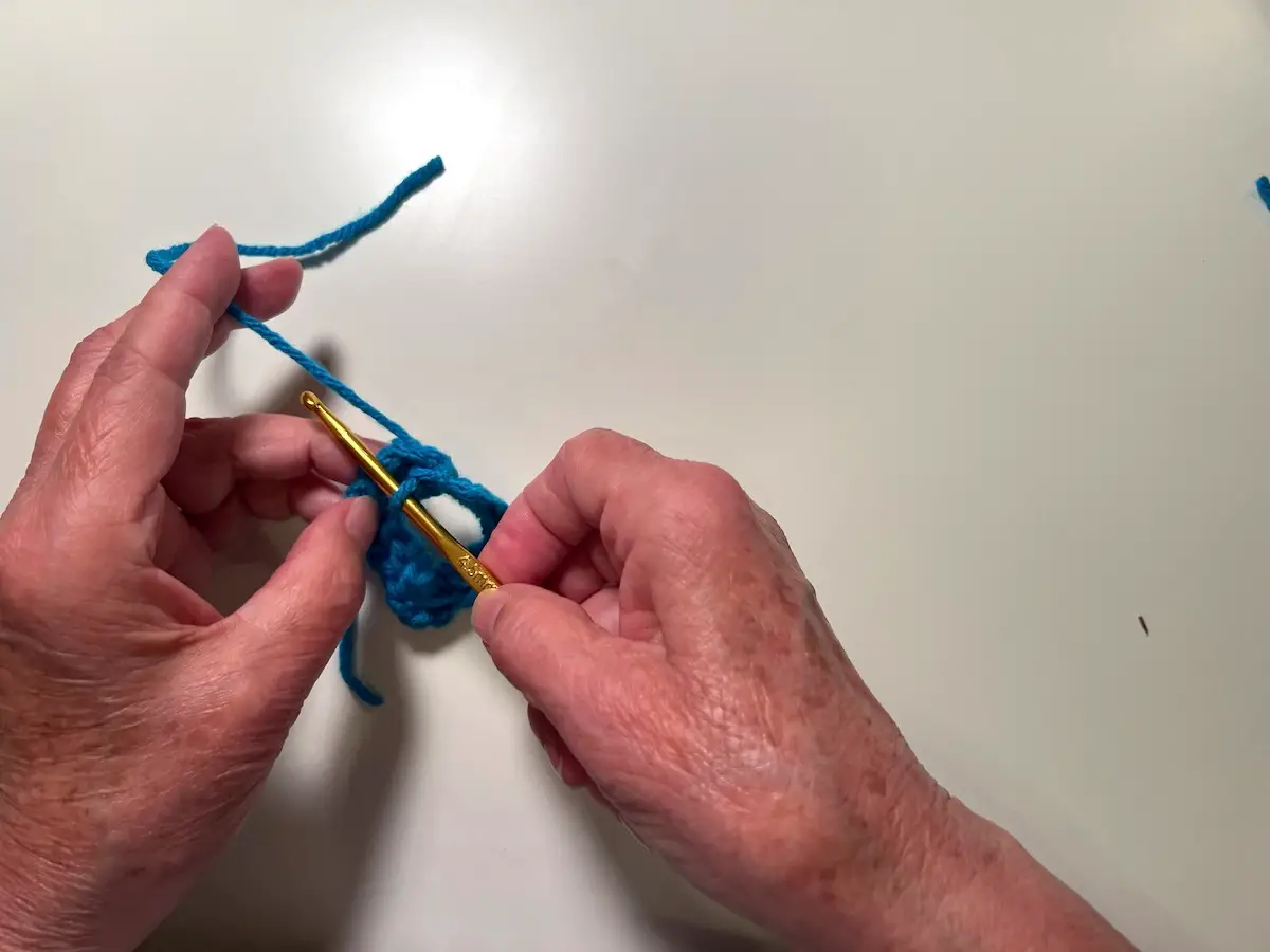 Cut the working yarn with about 6-7 inches and pull it through the stitch to finish the first round for the granny square