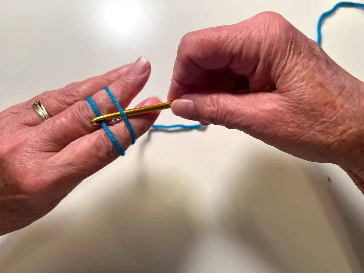 Place your hook under the yarn closest to you and pick up the furthest yarn with your hook for the magic circle for the granny square