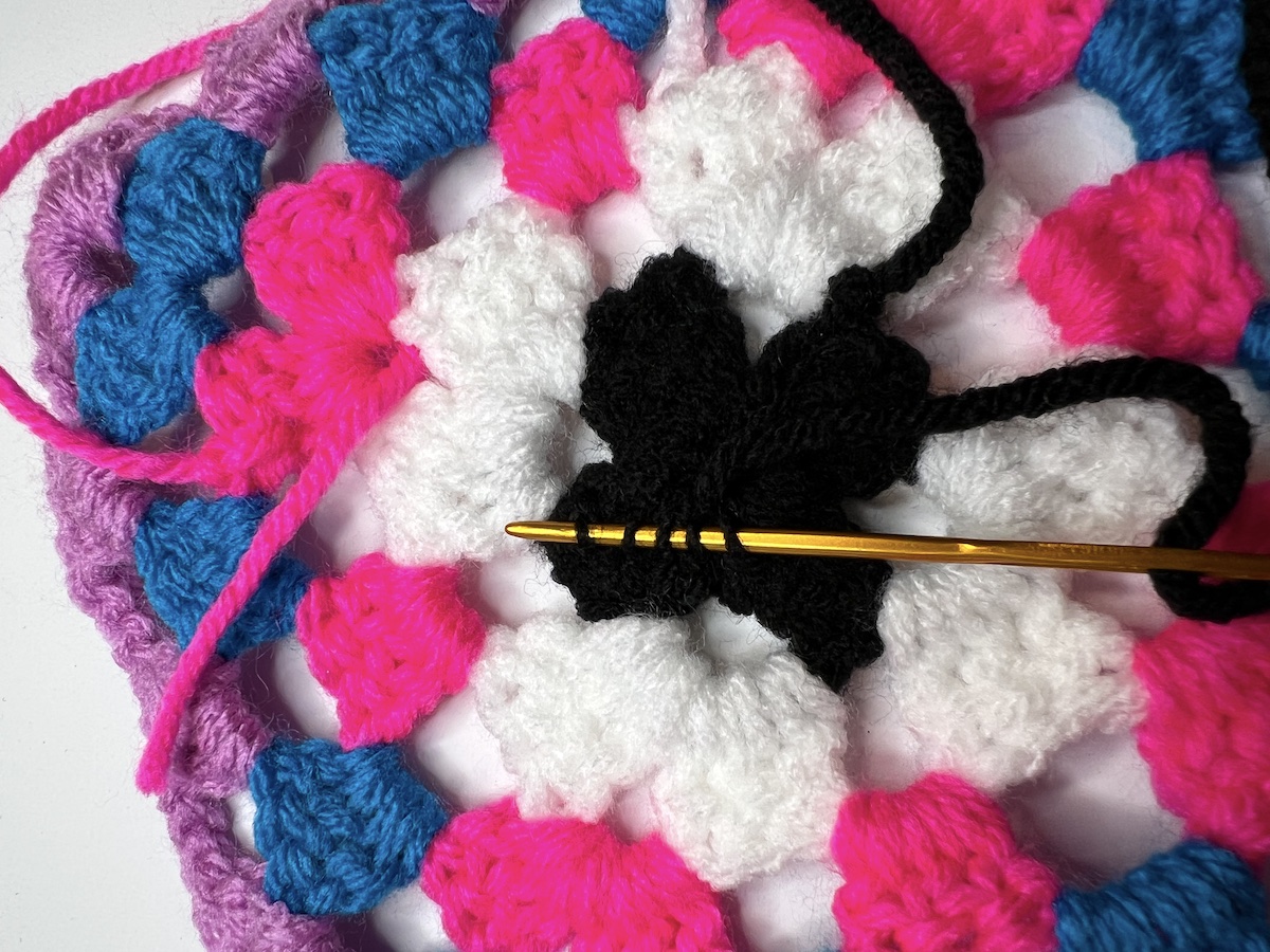 Turn your work and pick up another 5 threads going the other direction on the back of your granny square