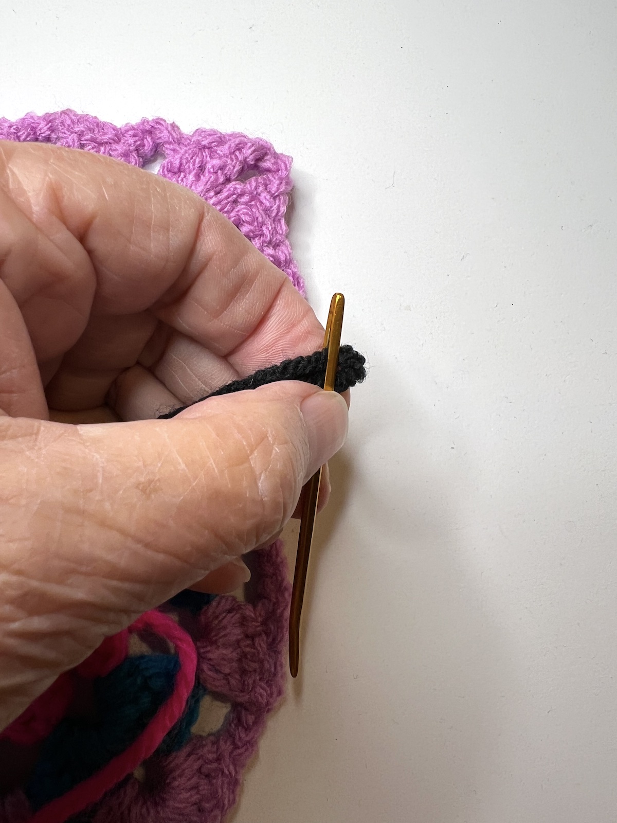 Place the folded edge of the yarn through the eye of the needle