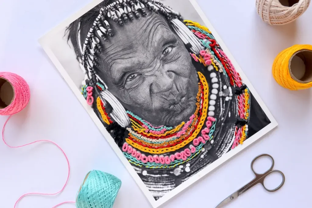 African person with embroidered necklaces and earring by Katia Herrera