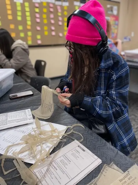 A student cutting out a pattern in the class of Qristy Kurtz