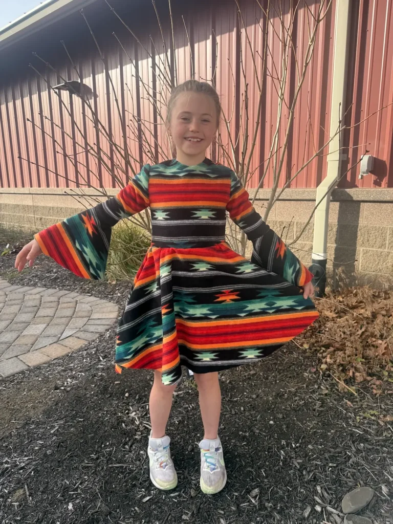 A student happy in her dress she finished in a class with Qristy Kurtz