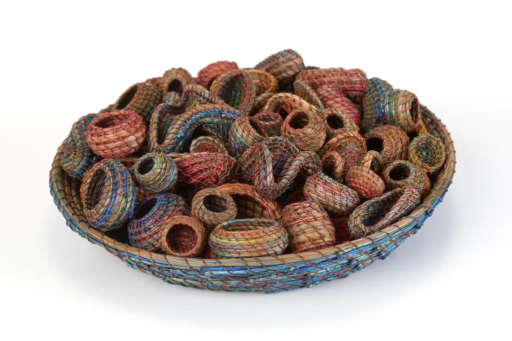 Large pine needle basket filled with small baskets by Clay Burnette