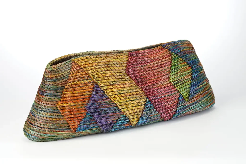 Colorful oblong pine needle basket woven by Clay Burnette