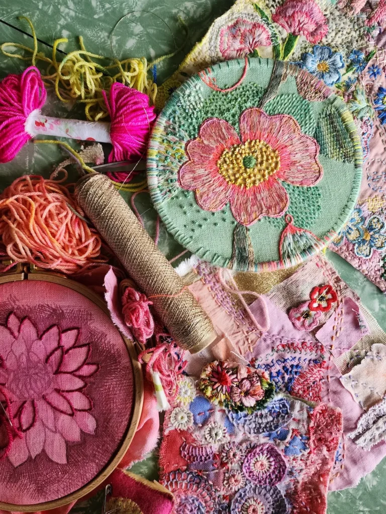 Peach embroidered flower on a seafoam green linen by Fleur Woods